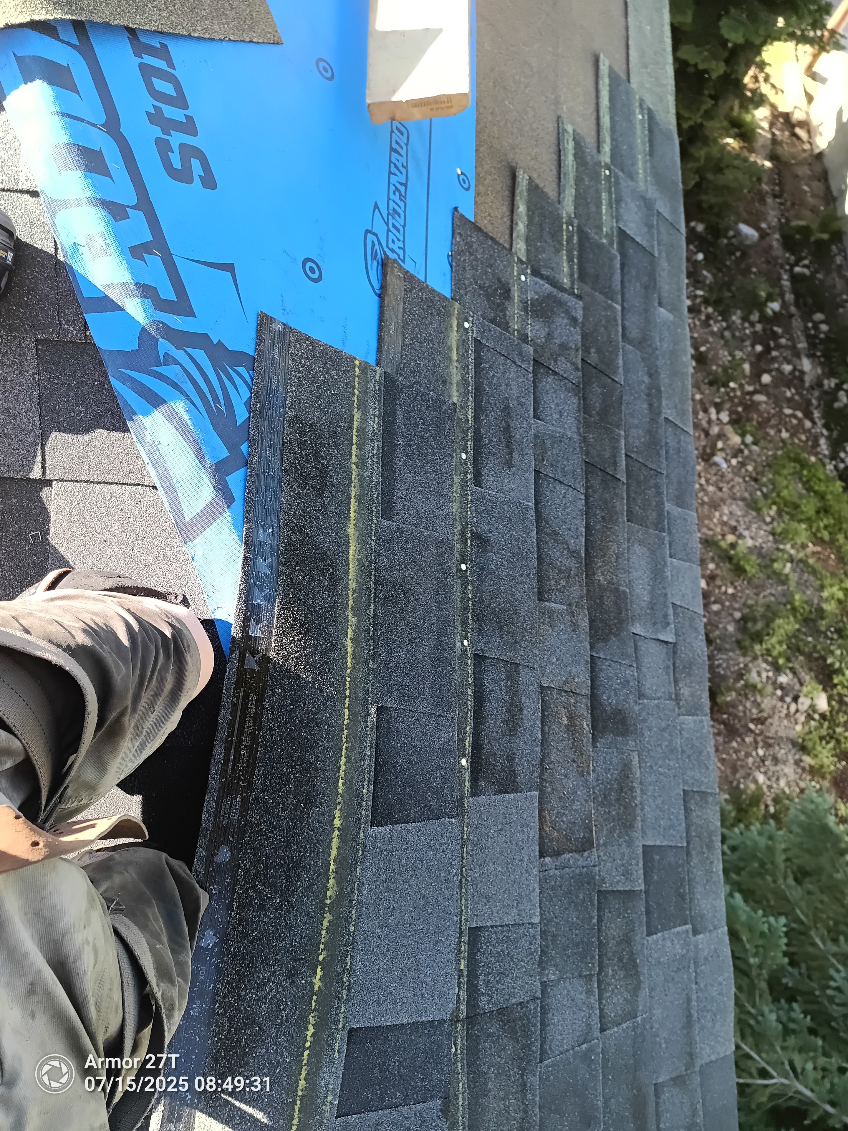Close-up of shingle installation with blue StormTred membrane on steep roof face