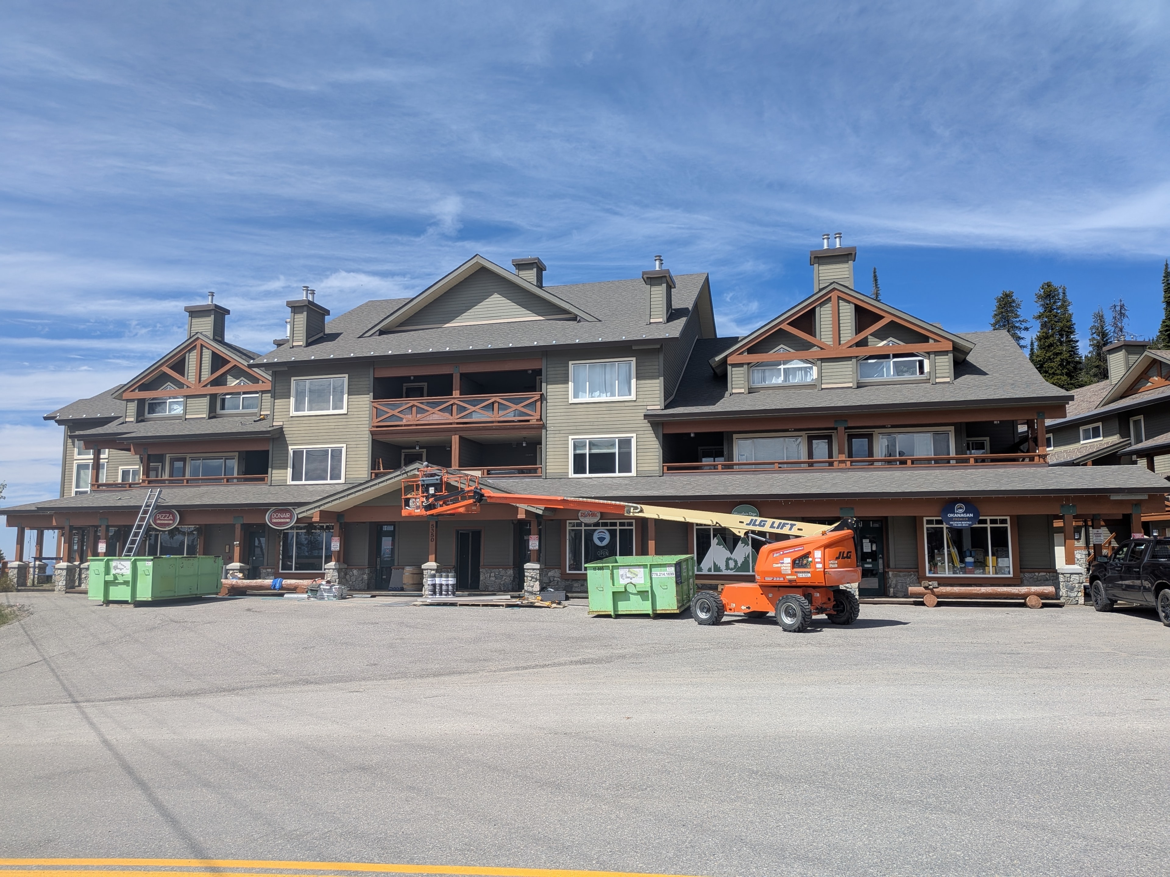 Large commercial building at Big White Ski Resort with completed roofing and JLG lift