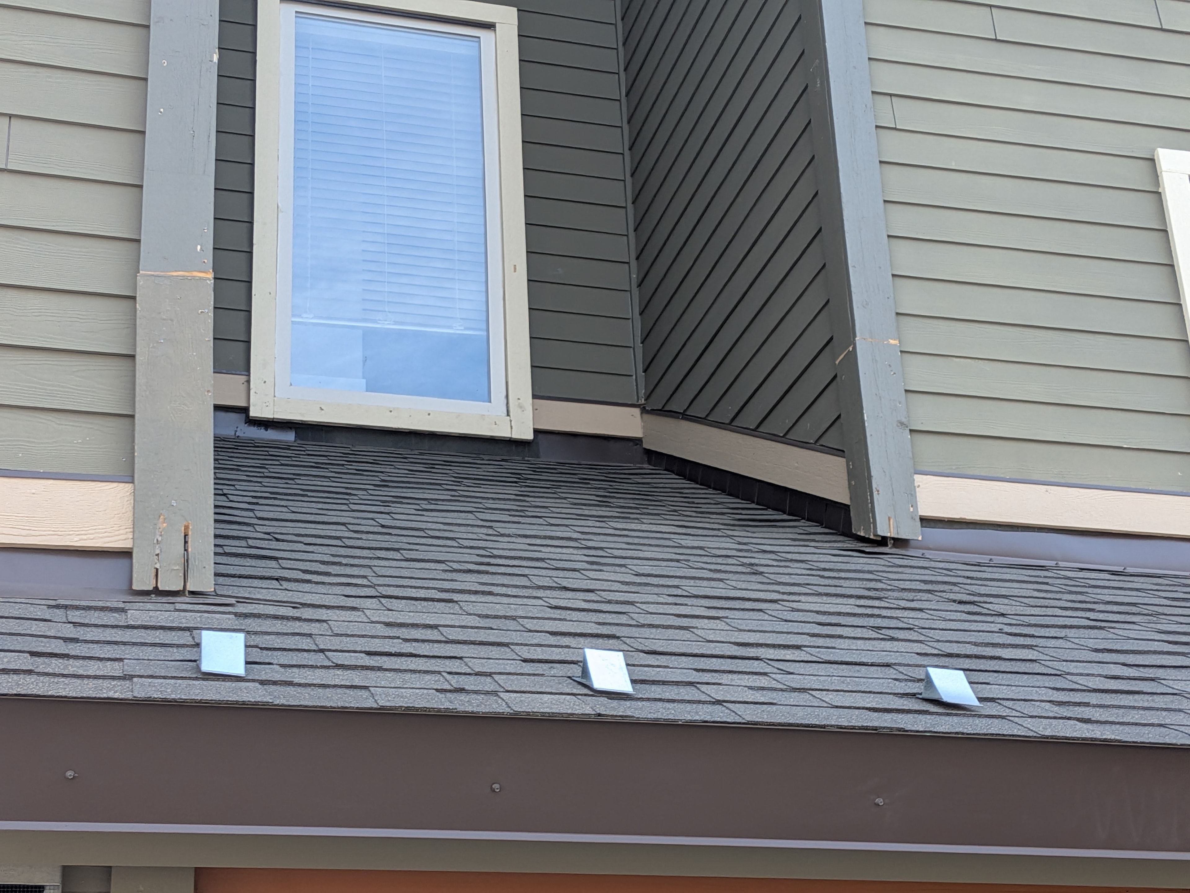 Completed dark shingle roof with drip edge on new construction townhome