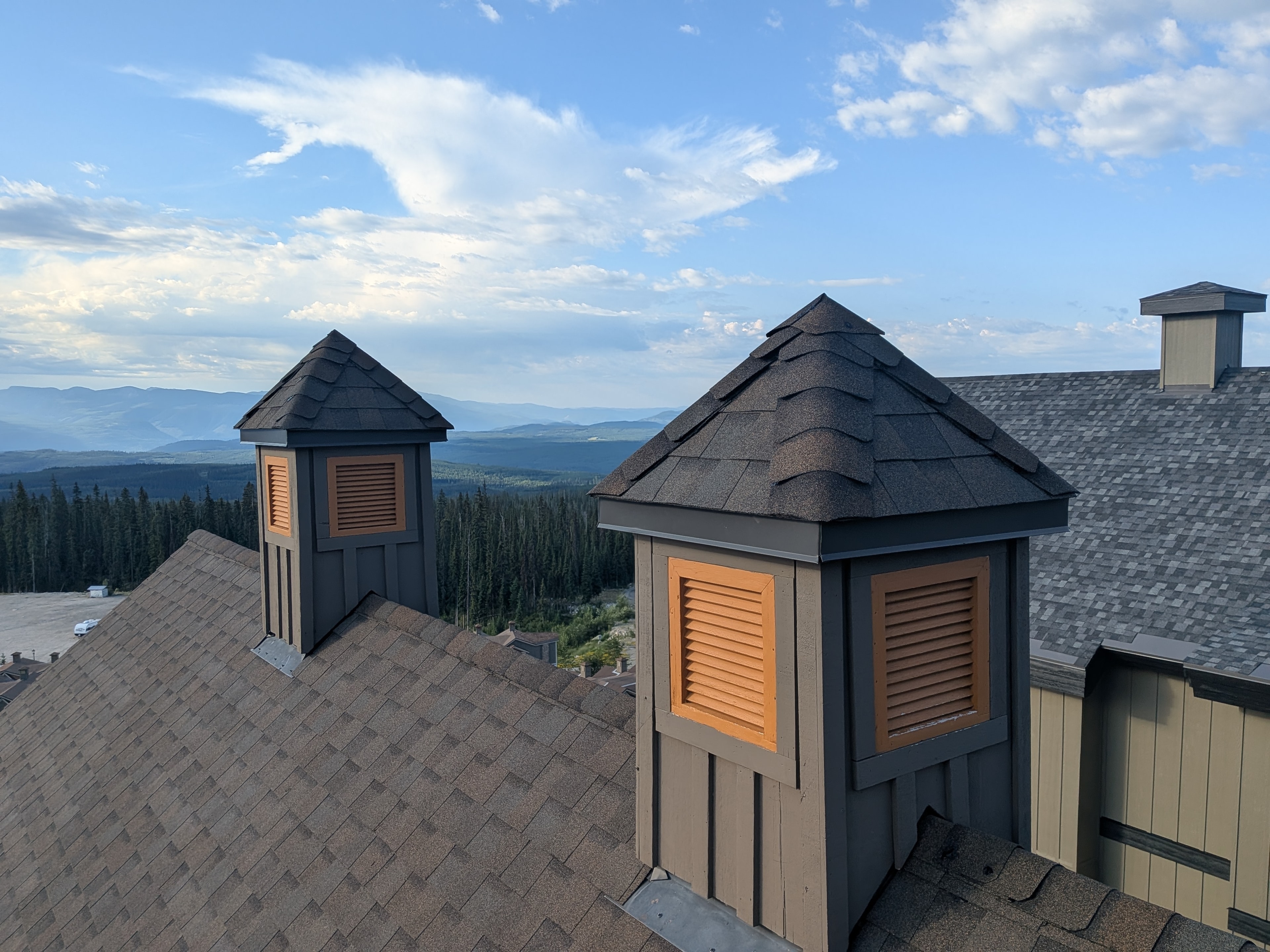 Rooftop cupolas with dark shingles and mountain valley views at Big White Ski Resort