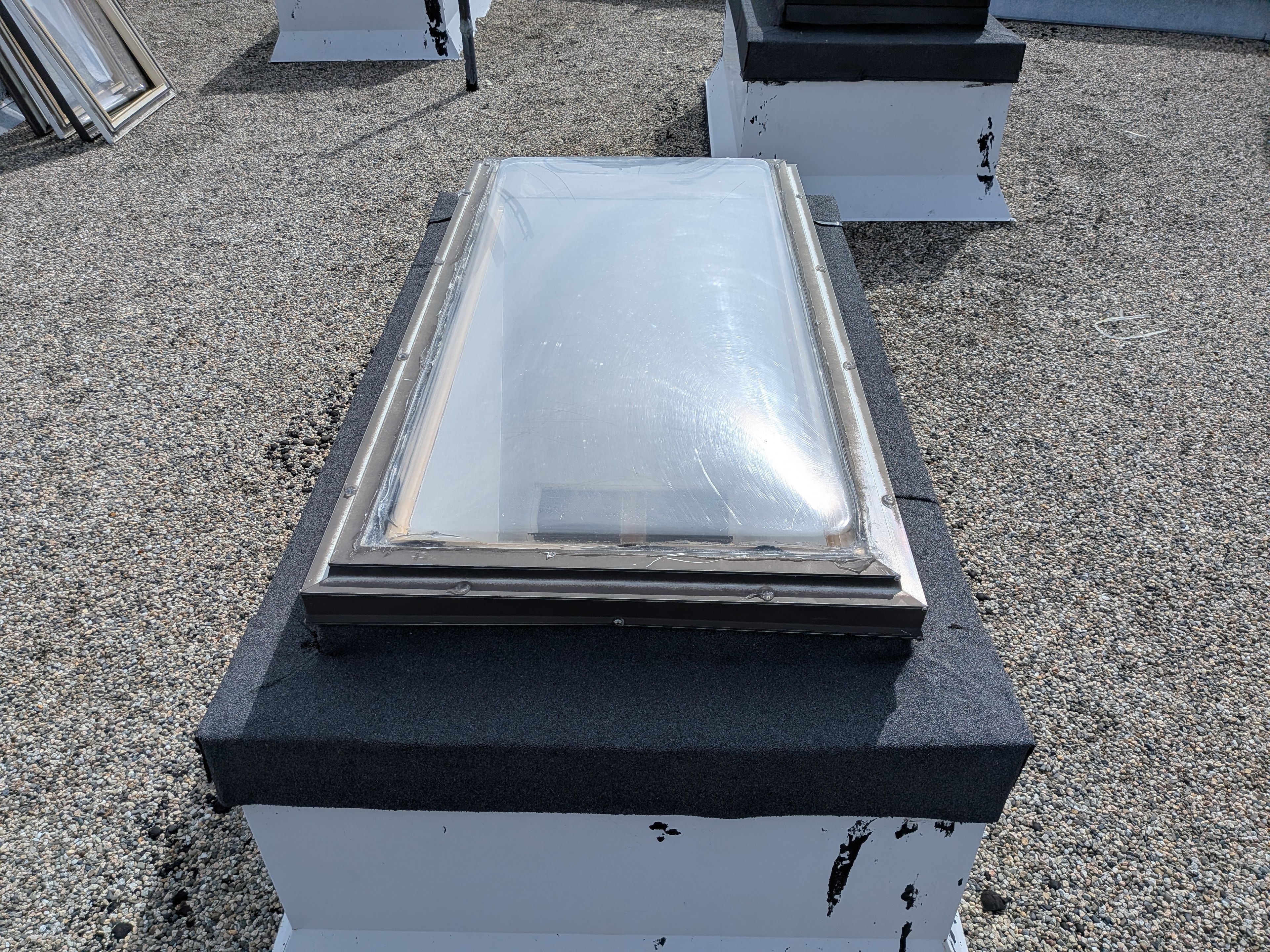 Skylight unit installed on flat torch-on membrane roof