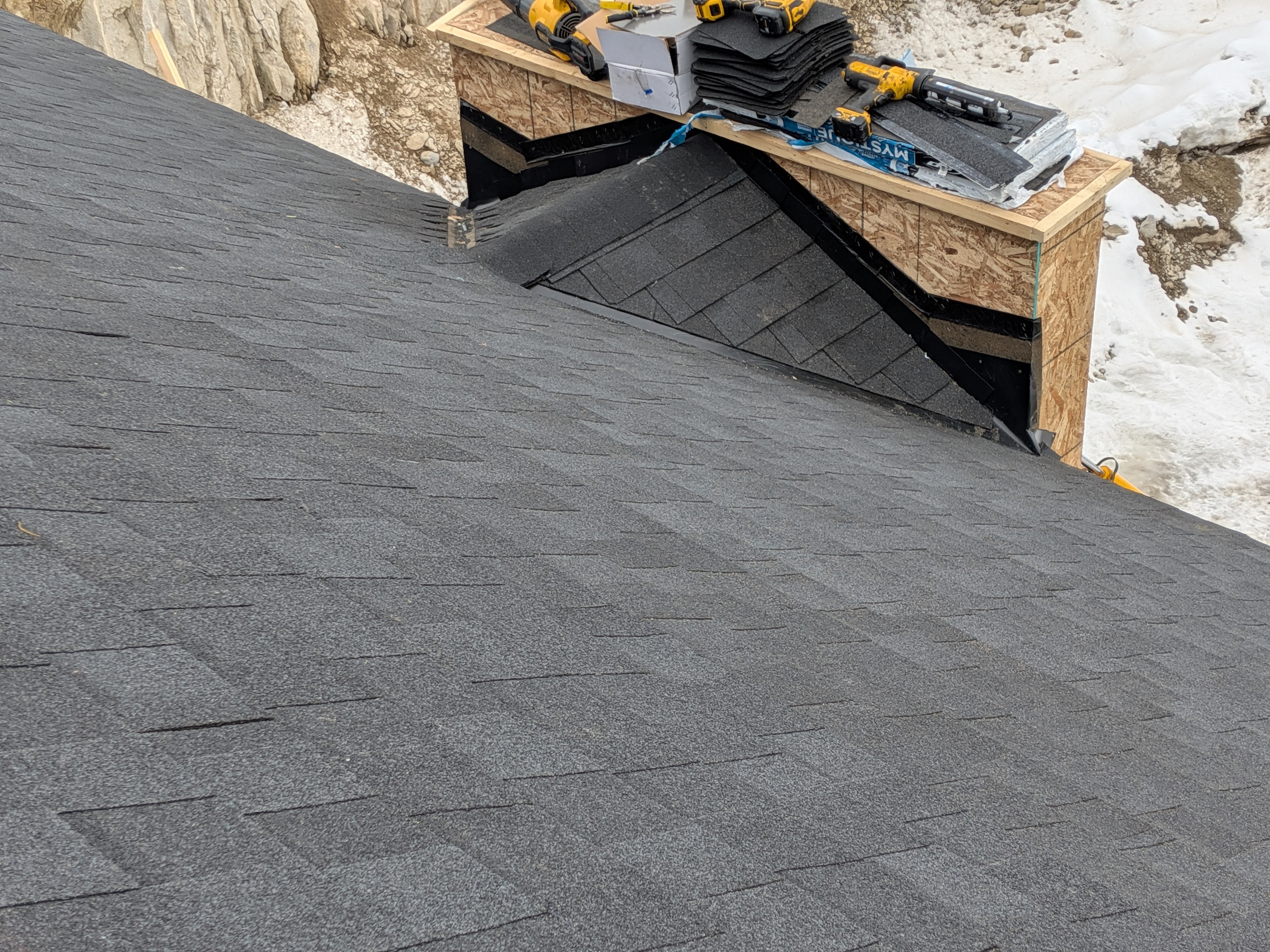 Close-up of dark shingle installation with valley flashing and Mystique shingles at Big White
