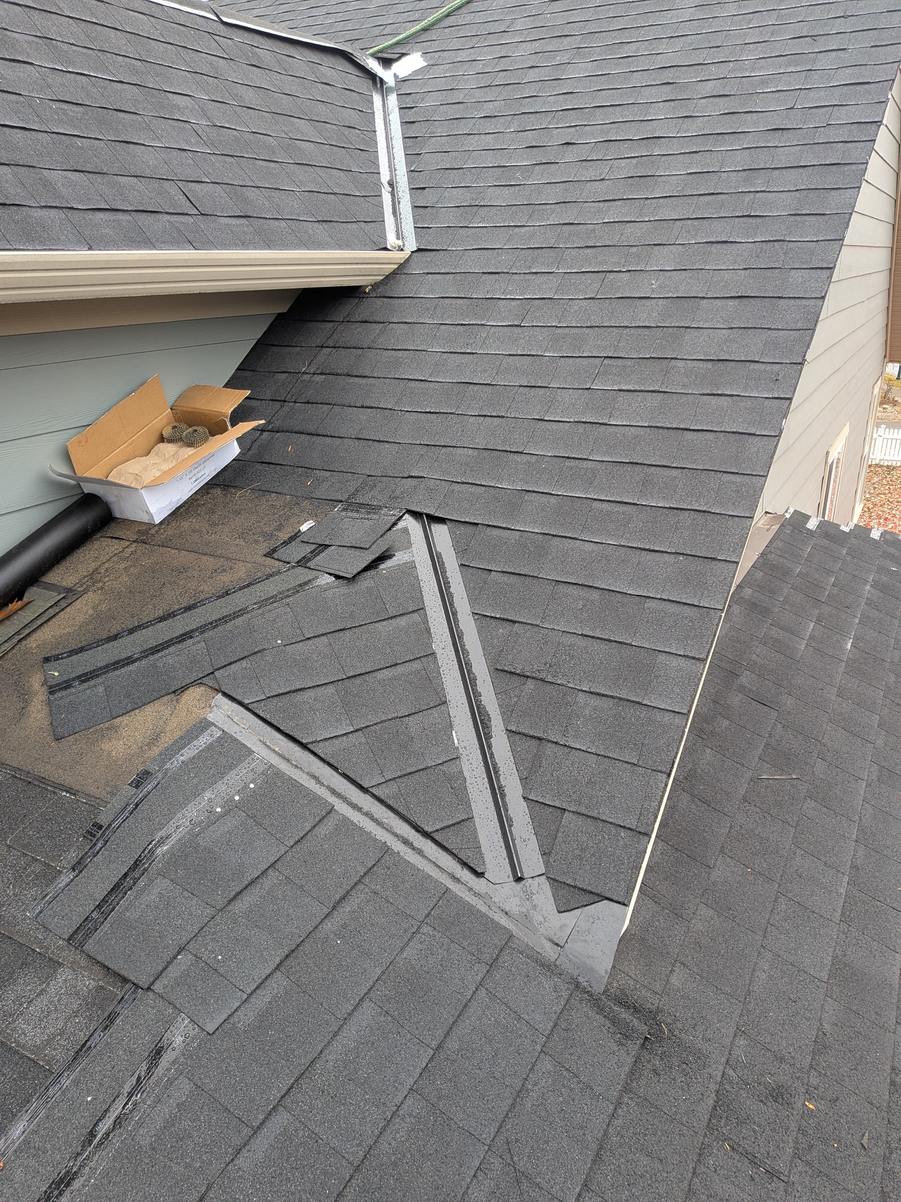 Shingle reroof in progress with new drip edge and old shingles being torn off