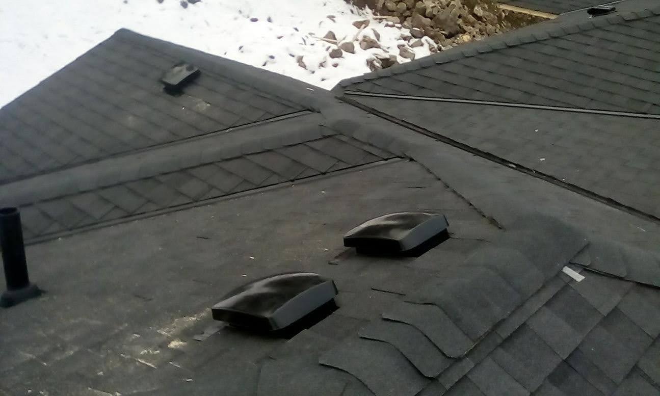 Completed residential roof with roof vents and snow in background